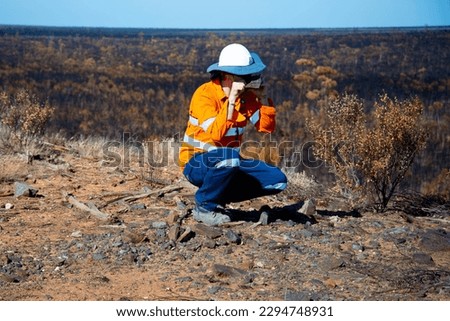 Exploration Geologist Examining a Rock Royalty-Free Stock Photo #2294748931