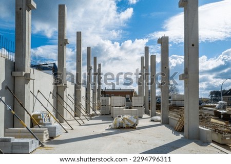 many concrete pillars for a factory building are erected on a construction site Royalty-Free Stock Photo #2294796311