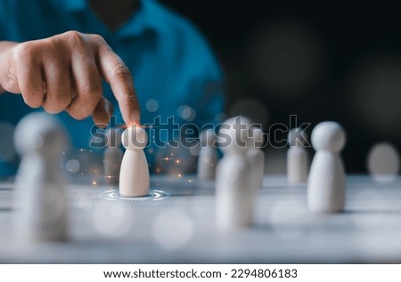Businessman choosing wooden figure hiring, business tactics and strategy. Leadership of business success. Organization development. Personnel selection. Human resource management concept. Royalty-Free Stock Photo #2294806183