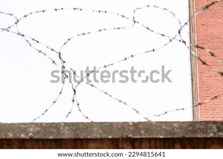 barbed wire prison fence. Selective focus, tinted image, bright sky