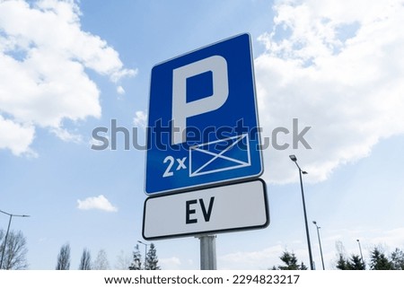 Electric vehicles charging station point. D-18a car parking reserved space sign and EV plate, marking of EV cars charger station, road signs in Poland.