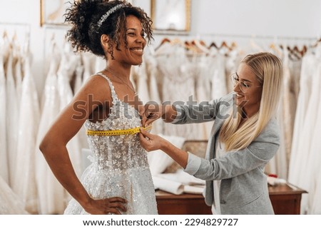 Measuring chest circumference on a bride in a wedding dress Royalty-Free Stock Photo #2294829727