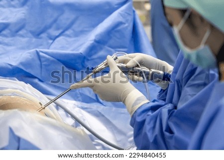 Team of doctor or surgeon and nurse in blue gown inside operating room did minimal invasive spine surgery technology with medical instrument.Disc surgery in sciatica pain.Close up at instrument. Royalty-Free Stock Photo #2294840455