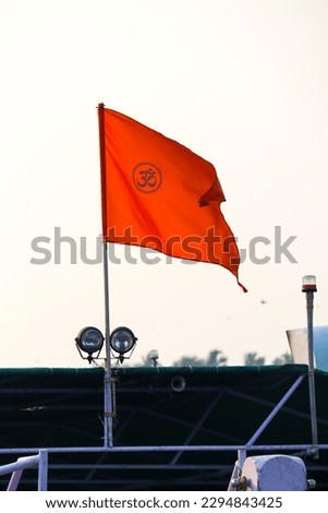 the hindu flag flying with clear sky in the background om written on it