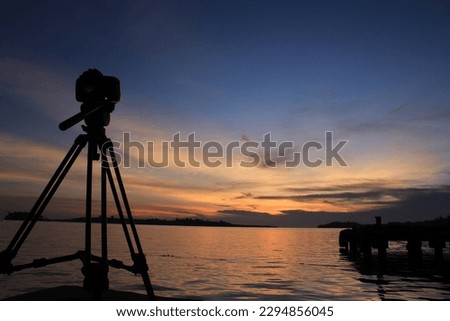 Beautiful sunset with camera silhouette in the foreground