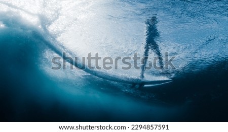 Underwater view of the surfer riding the wave in the Maldives Royalty-Free Stock Photo #2294857591