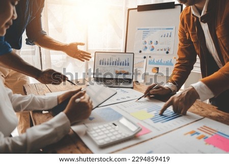 Young colleagues discuss business and analytical price charts using calculators and laptops to calculate financial, tax, accounting, statistics and analytical research ideas. Royalty-Free Stock Photo #2294859419