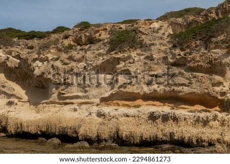 The image captures the stunning rocky coastline of Sardinia, Italy, with its natural ruggedness and texture. 