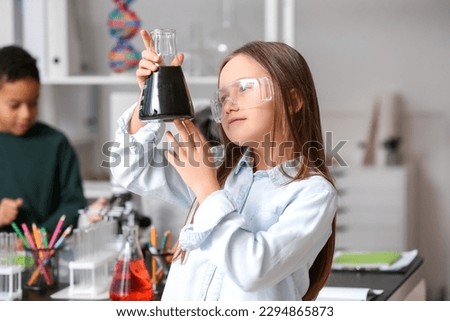 Little girl with conical flask in science classroom Royalty-Free Stock Photo #2294865873