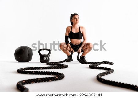 Young female athlete training in a gym using sport equipment. Fit woman working out . Concept about fitness, wellness and sport preparation. Royalty-Free Stock Photo #2294867141