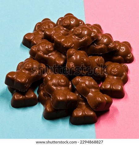 A pile of chocolate bears laid out on pink and blue card. A good mage for a confectionery store.