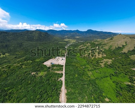 Golo Mori – Labuan Bajo Super Premium Tourism Destination where Asean Summit will held. Aerial view of a road in green meadows and hills with beach and mountains. Road to Golo Mori Mice.