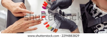 Manicure master helping to choose polish color in studio