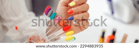 Woman client with palette of nail varnishes in beauty shop