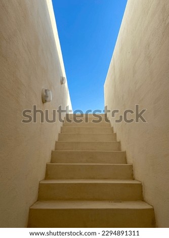 Modern white staircaise leading to rooftop and blue sky