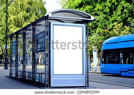 bus shelter at busstop. blank white lightbox. empty billboard. bus shelter ad. glass structure. digital lightbox. urban setting. European city street background. concrete sidewalk. base for mockup.
