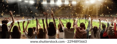 Back view of football, soccer fans emotionally cheering their team at crowded stadium at evening time. Hobby of millions of people. Concept of sport, cup, world, team, event, competition Royalty-Free Stock Photo #2294895663