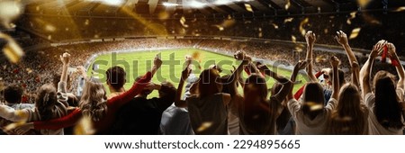Back view of football, soccer fans cheering their team with flag and posotove emotions at crowded stadium at evening time. Concept of sport, cup, world, team, event, competition Royalty-Free Stock Photo #2294895665