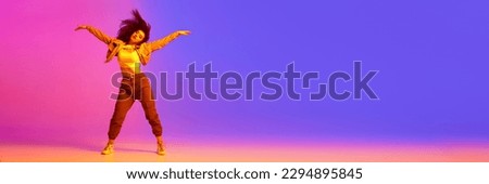 Young girl in sport style clothes dancing hip-hop against gradient pink purple background in neon light. Concept of contemporary dance, youth, hobby, action and motion. Banner. Copy space for ad