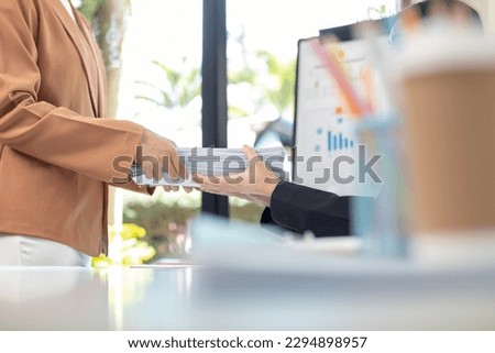Businesswoman hands working on stacks of paper documents to search and review documents piled on table before sending them to board of directors to use  correct documents in meeting with Businessman Royalty-Free Stock Photo #2294898957