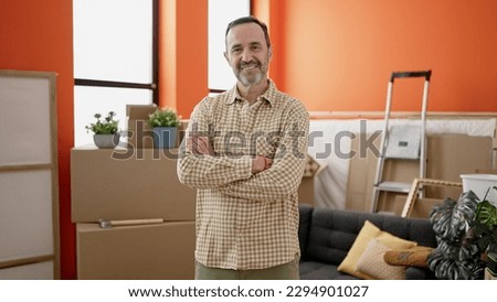 Middle age man smiling confident standing with arms crossed gesture at new home Royalty-Free Stock Photo #2294901027