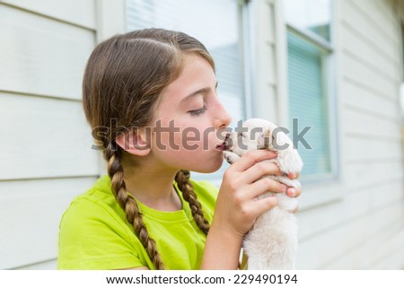 Girl playing kissing puppy chihuahua pet dog outdoor