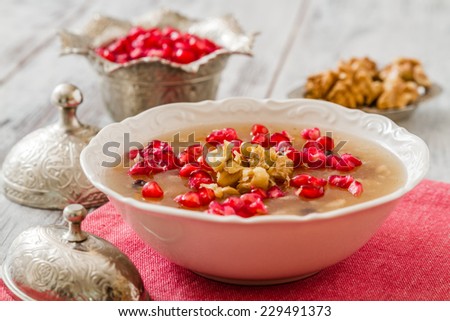 Turkish dessert Ashura, Noah's pudding, with pomegranate seeds and walnuts Royalty-Free Stock Photo #229491373