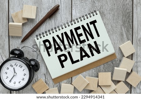 PAYMENT PLAN text on an open notepad on the table. text on wooden blocks Royalty-Free Stock Photo #2294914341