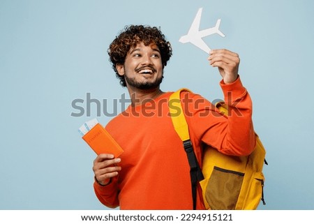 Traveler young teen boy student man wear casual clothes backpack bag hold passport ticket mock up of plane isolated on plain blue background. Tourist travel abroad to study. Air flight trip concept Royalty-Free Stock Photo #2294915121