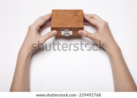 A woman(female) two hands hold a empty(blank) wooden box with hinge for accessory isolated white, top view, studio.