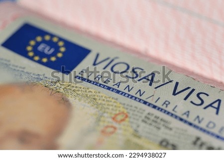 close-up part of page of document, foreign passport for travel with European Ireland visa, tourist visa stamp with hologram with shallow depth of field, passport control at border, travel in Europe