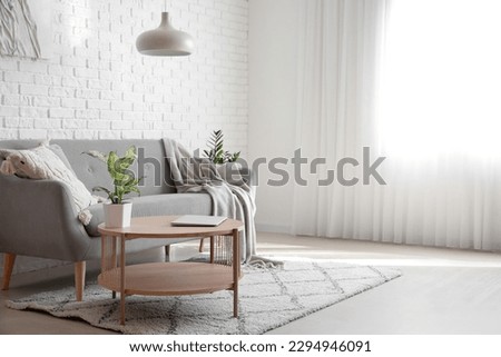 Interior of bright living room with modern laptop on coffee table Royalty-Free Stock Photo #2294946091
