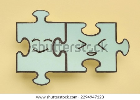 Puzzle pieces with happy faces on beige background. Friendship Day celebration