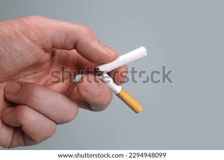 Hand breaks cigarette, quit smoking concept