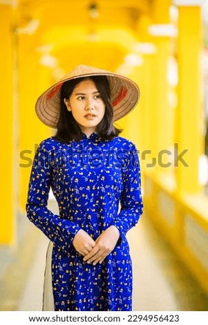 Beautiful Asian woman dress in Ao Dai Vietnamese long dress  the Vietnamese national costume with Vietnamese conical hat. Royalty-Free Stock Photo #2294956423