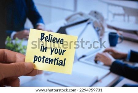 Male hand holding sticky note written Believe in your potential.