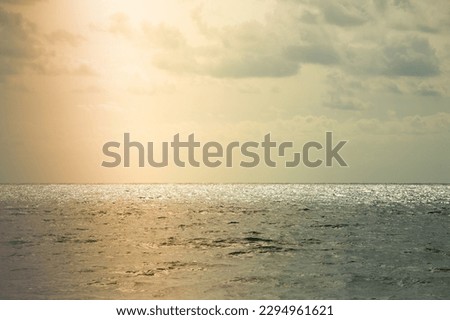 SEA LANDSCAPE WITH SUN LIGHT IN THE CLOUDY SKY BEFORE THE STORM, STORMY WEATHER BACKGROUND