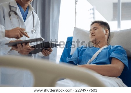 Accident, health and people concept. Doctor talking to male patient on hospital bed.