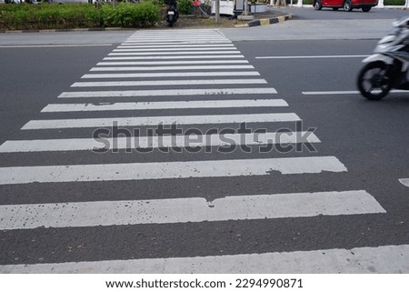 Jakarta, Indonesia, April 28, 2023,  A zebra crossing or a marked crosswalk is a pedestrian crossing marked with white stripes or zebra markings.