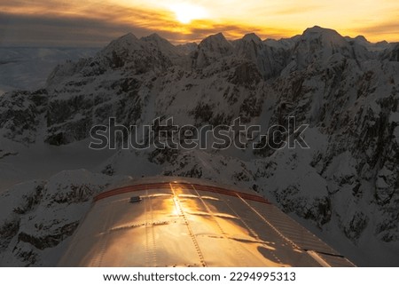 Aerial view of Alaska Range mountains at sunset with airplane wi Royalty-Free Stock Photo #2294995313