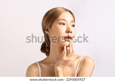 The beautiful Asian woman showing clear skin on the white background.