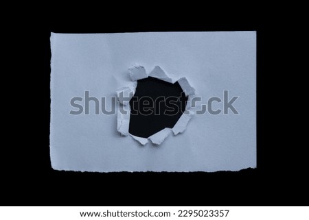 Ripped white paper piece isolated on a black background