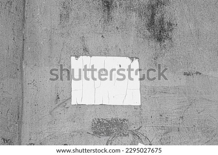 Blank white paper stuck on old concrete wall with black stains. Copy space