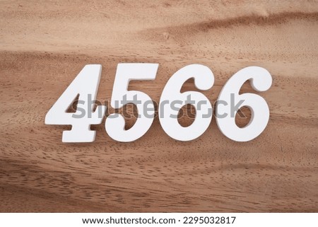 White number 4566 on a brown and light brown wooden background.