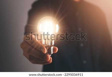 Business man holding light bulb. New idea, innovation technology and creative concept. Royalty-Free Stock Photo #2295036911