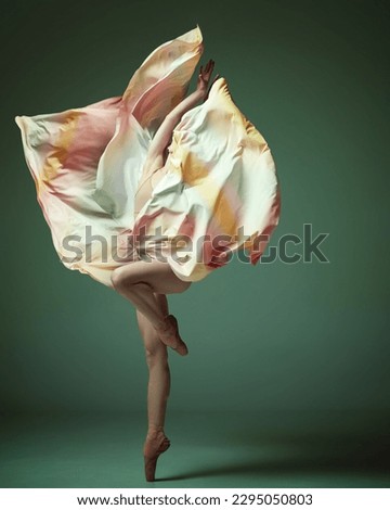 Ballerina. Young classical dancer wearing colorful flying dress dancing on fingertips over dark green studio background. Concept of ballet, inspiration, beauty, contemporary dance, creativity, ad