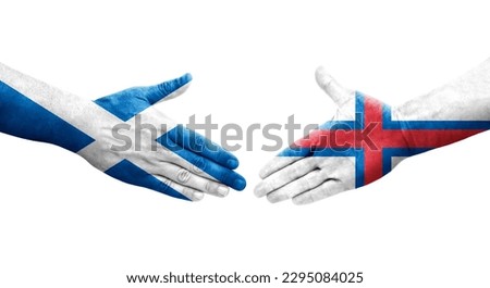 Handshake between Faroe Islands and Scotland flags painted on hands, isolated transparent image.
