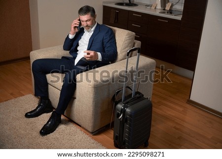 Adult male talking on smartphone in the hostel room Royalty-Free Stock Photo #2295098271