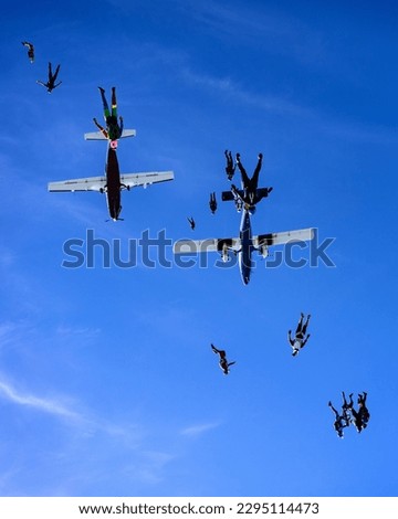 silhouette group of skydivers build head down freefly formation above clouds
