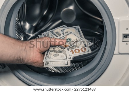 American dollars being put into the washing machine, Concept, Money laundering, Illegal business proceeds, Dark business, Black market, Bundle of 100 dollar bills Royalty-Free Stock Photo #2295121489